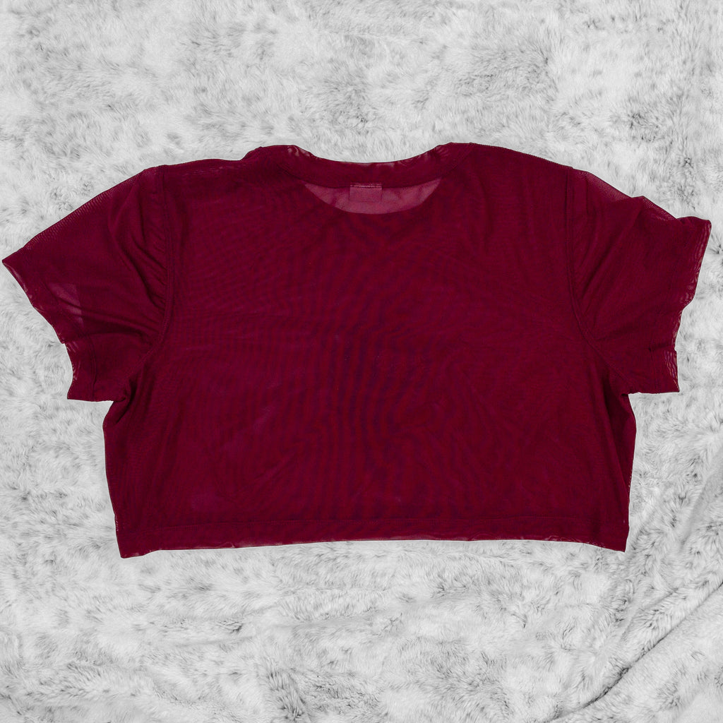 A flat lay image showcasing the back of a wine stretch mesh crop top tee shirt with short sleeves a round neckline. The background is neutral, highlighting the top's details and textures.