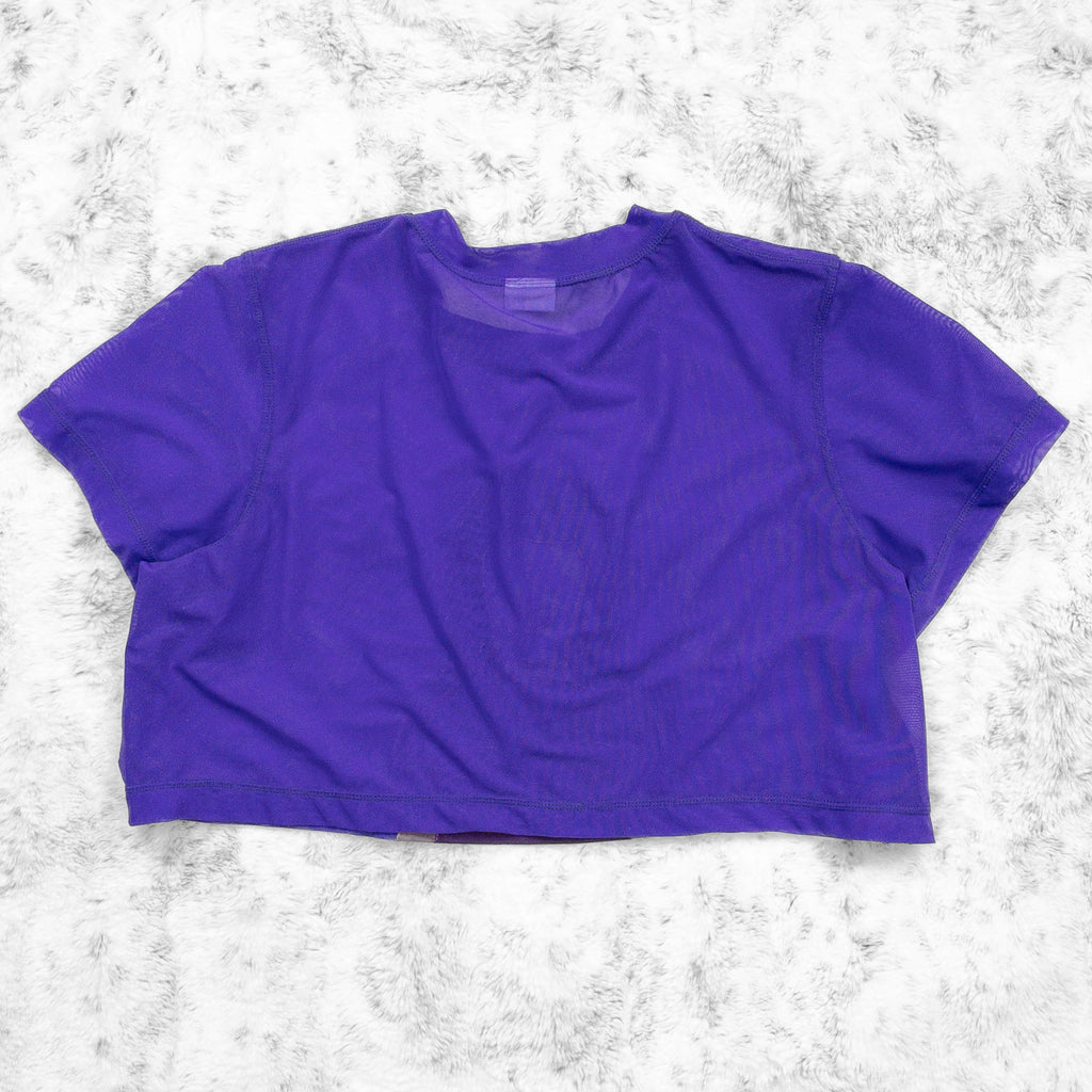 A flat lay image showcasing the back of a bright purple stretch mesh crop top tee shirt with short sleeves a round neckline. The background is neutral, highlighting the top's details and textures.