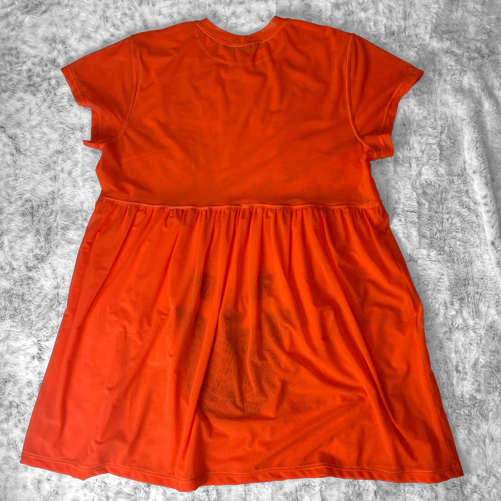 A flat lay image showcasing the back of a bright orange stretch mesh babydoll dress with short sleeves. The dress features soft, luxurious fabric in rich colors. The background is neutral, highlighting the dress's details and textures.